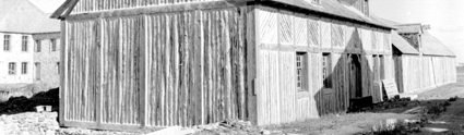 Reconstructed Dugas House in the foreground at the Fortress of Louisbourg  Parks Canada / Parcs Canada